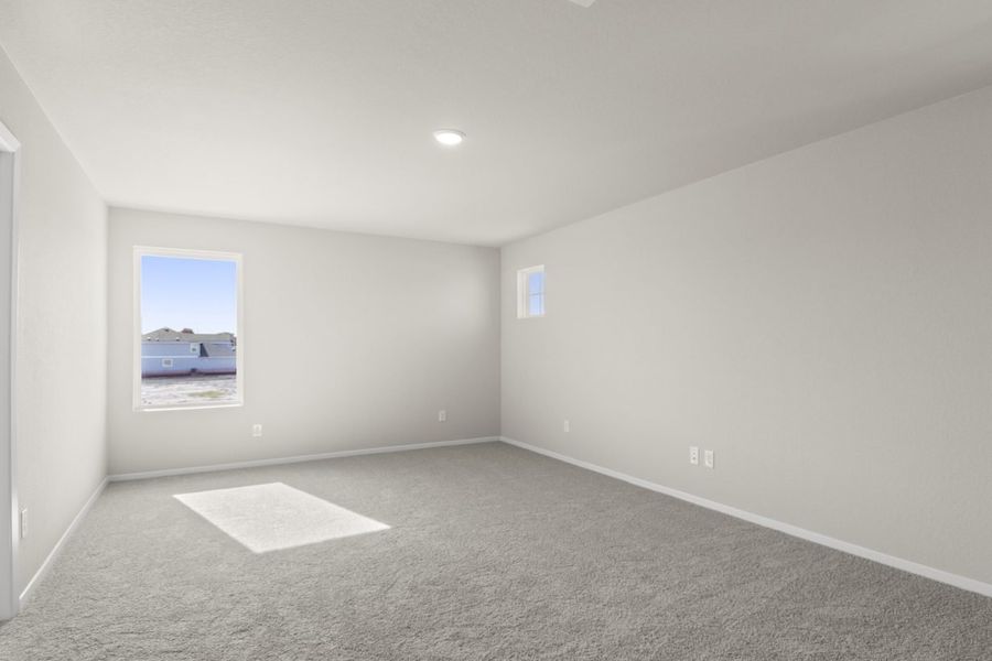 Image of a flex space room with light grey walls, tan carpeting and a window