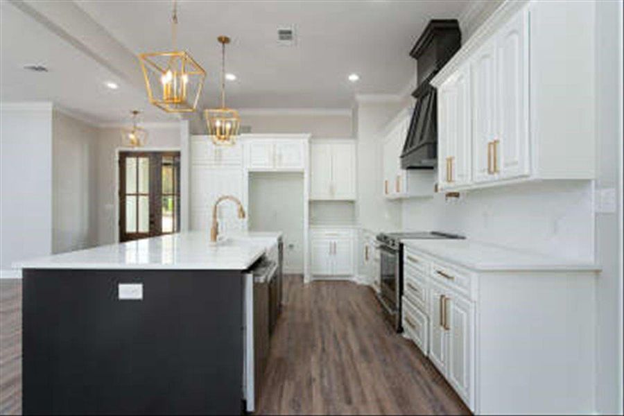 Kitchen featuring appliances with stainless steel finishes, white cabinetry, hanging light fixtures, recessed lighting, and crown molding