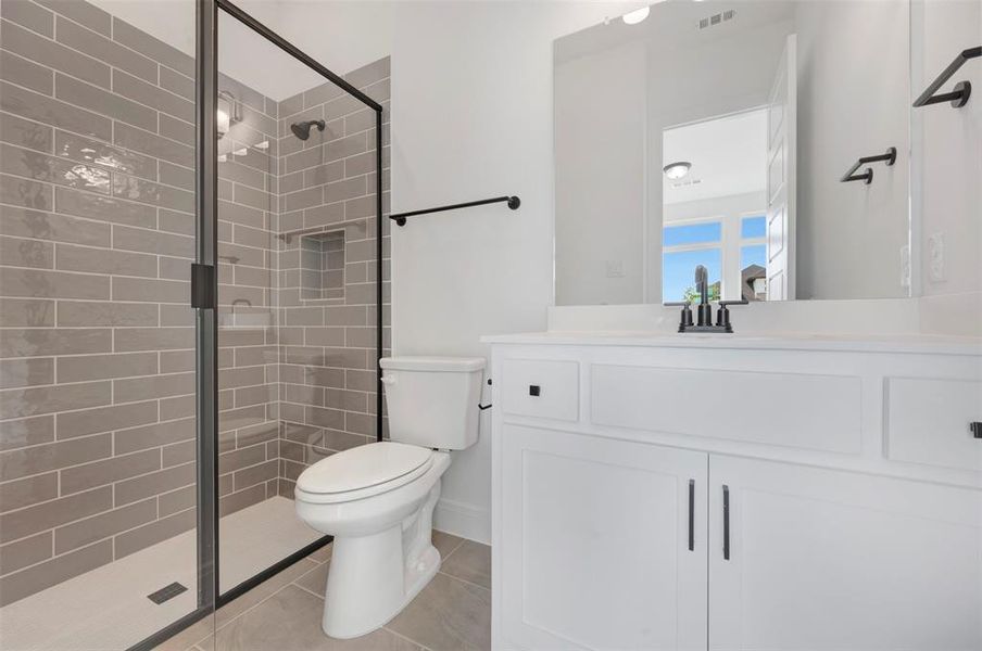 Bathroom with vanity, a shower stall, and light tile patterned flooring