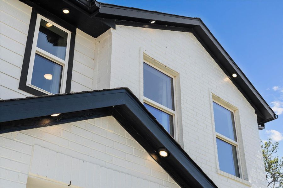 Make a bold statement with this stunning modern elevation, showcasing a high-contrast palette of crisp white siding and bold black architectural accents. The sophisticated roofline is defined by integrated recessed soffit lighting, providing an elegant nighttime glow and exceptional curb appeal. Make a bold statement with this stunning modern elevation, showcasing a high-contrast palette of crisp white siding and bold black architectural accents. The sophisticated roofline is defined by integrated recessed soffit lighting, providing an elegant nighttime glow and exceptional curb appeal.