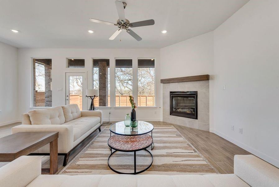 Living area featuring wood finished floors, recessed lighting, plenty of natural light, ceiling fan, and a tile fireplace