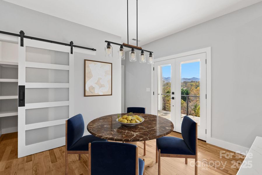 Virtually Staged - The dining area off the kitchen and a beautiful pantry behind the modern sliding barn door.