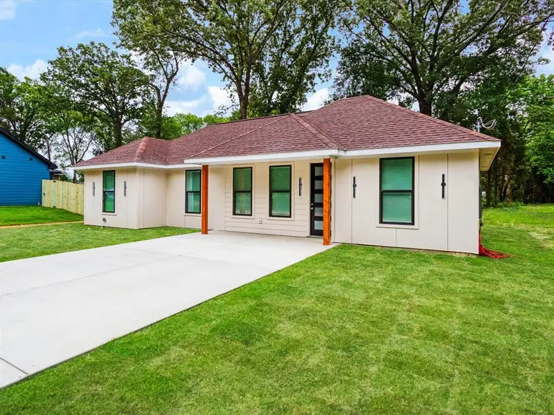 Contemporary single-story residence with a tan exterior and dark brown shingle roof Contemporary single-story residence with a tan exterior and dark brown shingle roof