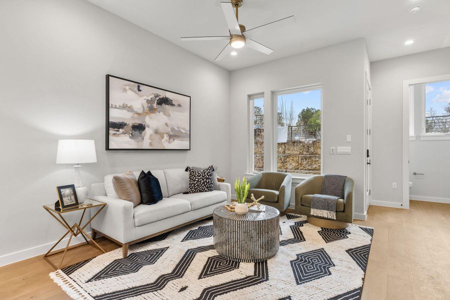 Living area with ceiling fan, light wood finished floors, recessed lighting, and baseboards