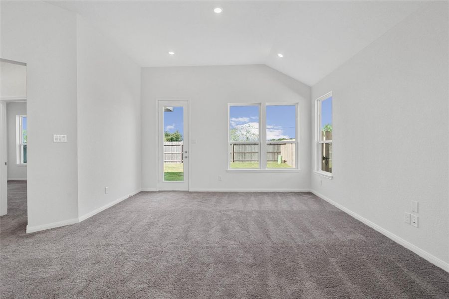 This bright and airy Great Room offers a spacious layout ideal for both relaxing evenings and lively gatherings. Designed for comfort and connection, it features plush carpeting, large windows, high ceilings, recessed lighting, and access door to the backyard.