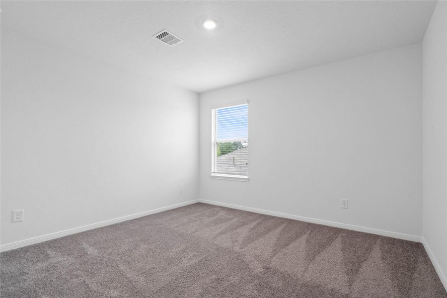 This secondary bedroom offers comfort and style with plush carpeting, neutral paint tones, recessed lighting, a large window, and a generously sized closet. This secondary bedroom offers comfort and style with plush carpeting, neutral paint tones, recessed lighting, a large window, and a generously sized closet.