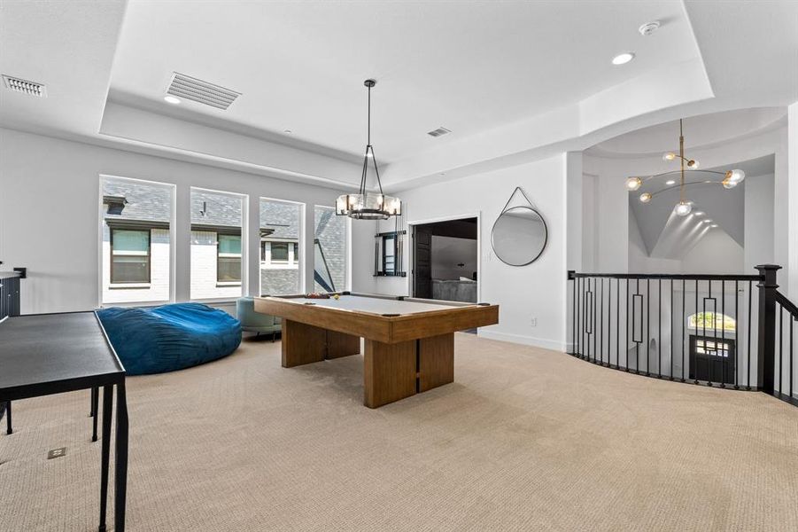 Game room featuring a chandelier, a raised ceiling, recessed lighting, and light colored carpet Game room featuring a chandelier, a raised ceiling, recessed lighting, and light colored carpet