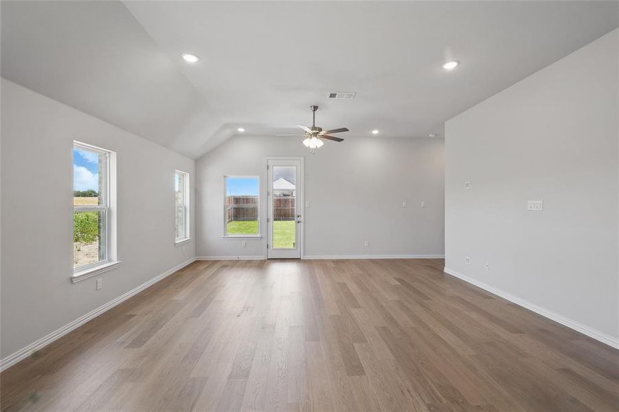 Unfurnished room featuring ceiling fan, wood finished floors, vaulted ceiling, baseboards, and recessed lighting
