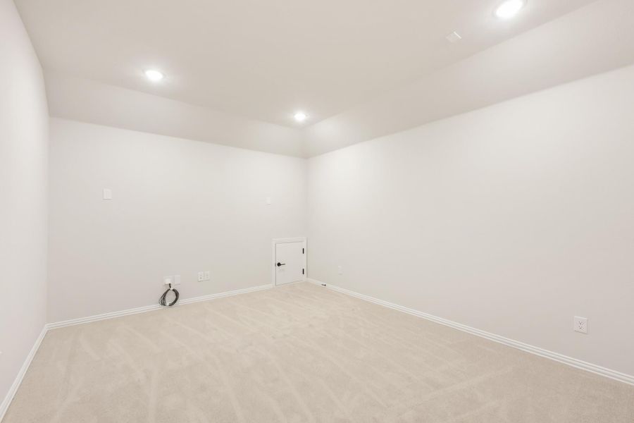 Empty room with white walls, beige carpet, recessed lighting, and a small access door