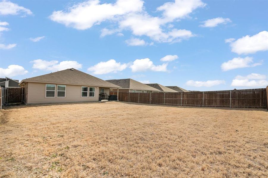 Rear view of house with a fenced backyard, a patio, and a gate Rear view of house with a fenced backyard, a patio, and a gate