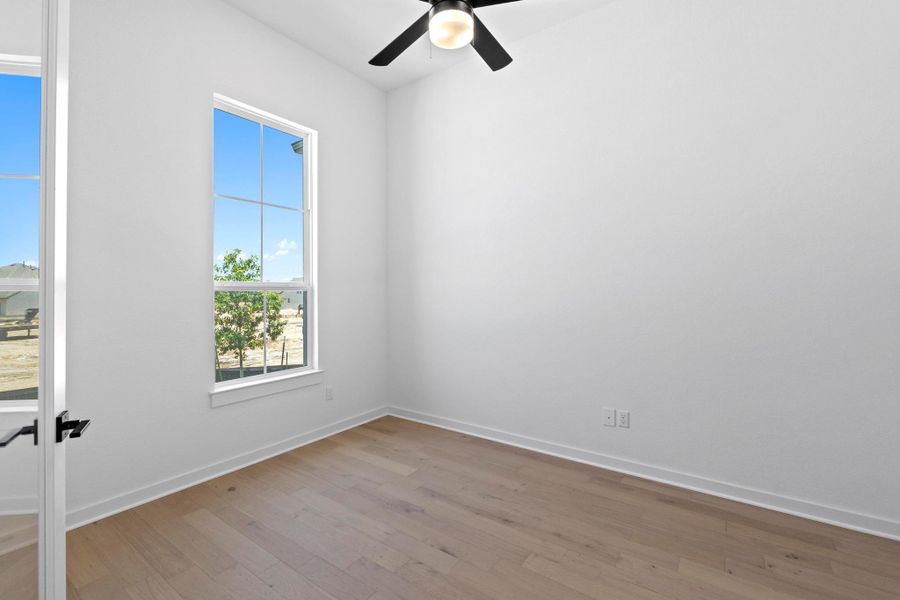 Spare room featuring light wood-style floors and a ceiling fan