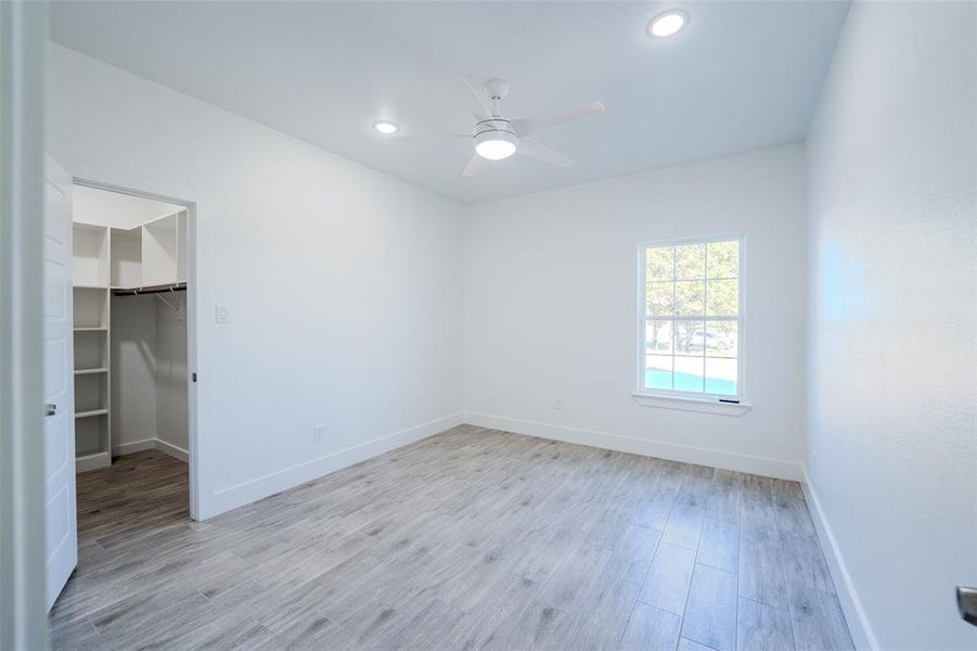 Bedroom (3) featuring light wood-type flooring, a ceiling fan, a walk in closet, and recessed lighting Bedroom (3) featuring light wood-type flooring, a ceiling fan, a walk in closet, and recessed lighting