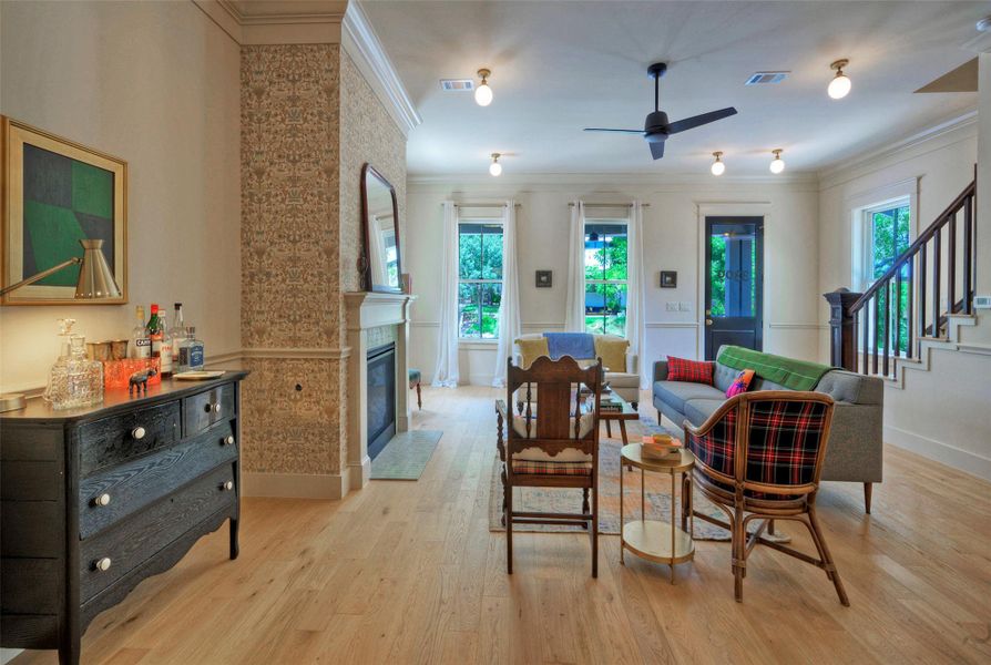Bright hardwood floors flow through this inviting living area, featuring a cozy fireplace and graceful staircase.