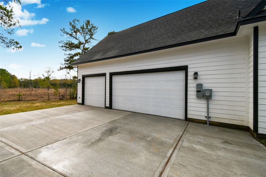 Convenience and style go hand-in-hand with this oversized attached garage. The three-car capacity and wide concrete driveway provide ample space for vehicles and storage. The garage in the left is also in the other side that opens completely through