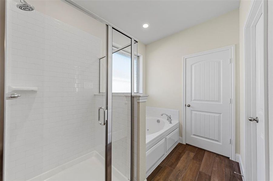 Bathroom featuring hardwood / wood-style flooring and plus walk in shower