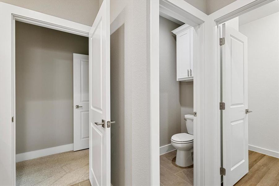 Bathroom featuring toilet and hardwood / wood-style floors Bathroom featuring toilet and hardwood / wood-style floors