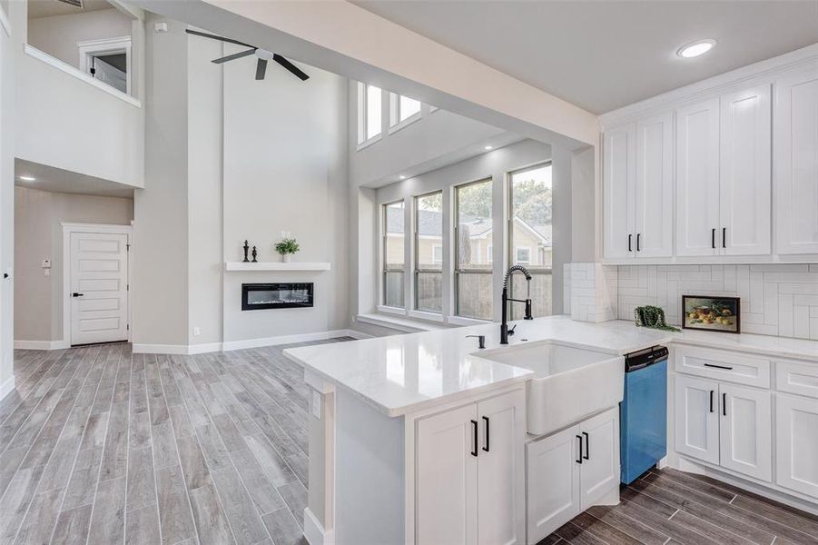 Kitchen featuring wood finish floors, ceiling fan, white cabinetry, tasteful backsplash, and recessed lighting