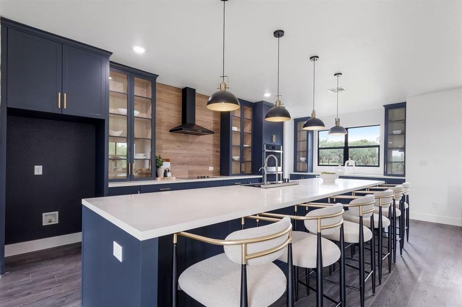 Expansive kitchen featuring a large central island with seating, a white countertop, and pendant lighting Expansive kitchen featuring a large central island with seating, a white countertop, and pendant lighting