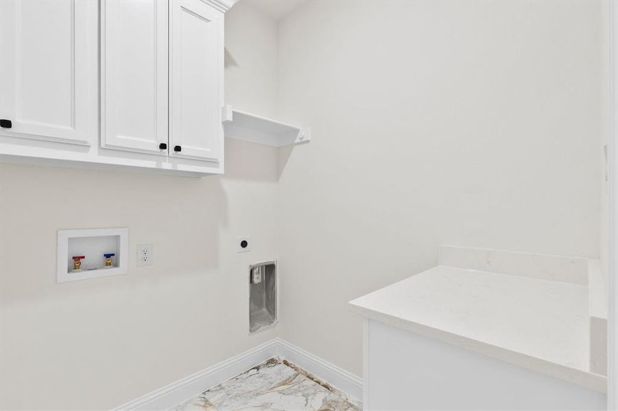 Laundry area featuring hookup for a washing machine, hookup for an electric dryer, baseboards, marble finish floor, and cabinet space Laundry area featuring hookup for a washing machine, hookup for an electric dryer, baseboards, marble finish floor, and cabinet space