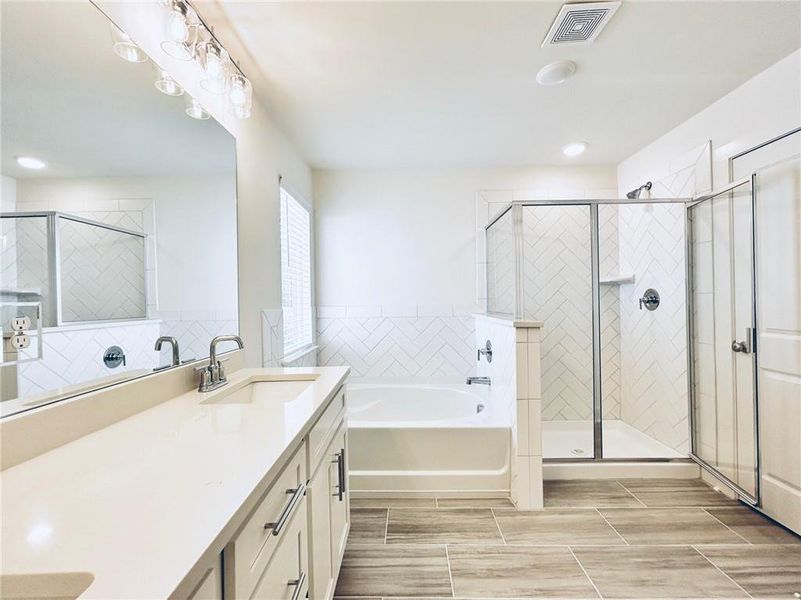 Bathroom with independent shower and bath, tile flooring, and oversized vanity