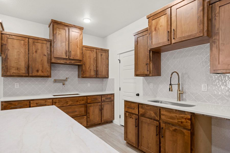 A well-equipped kitchen features ample cabinetry and a clean aesthetic with a dedicated pot filler.