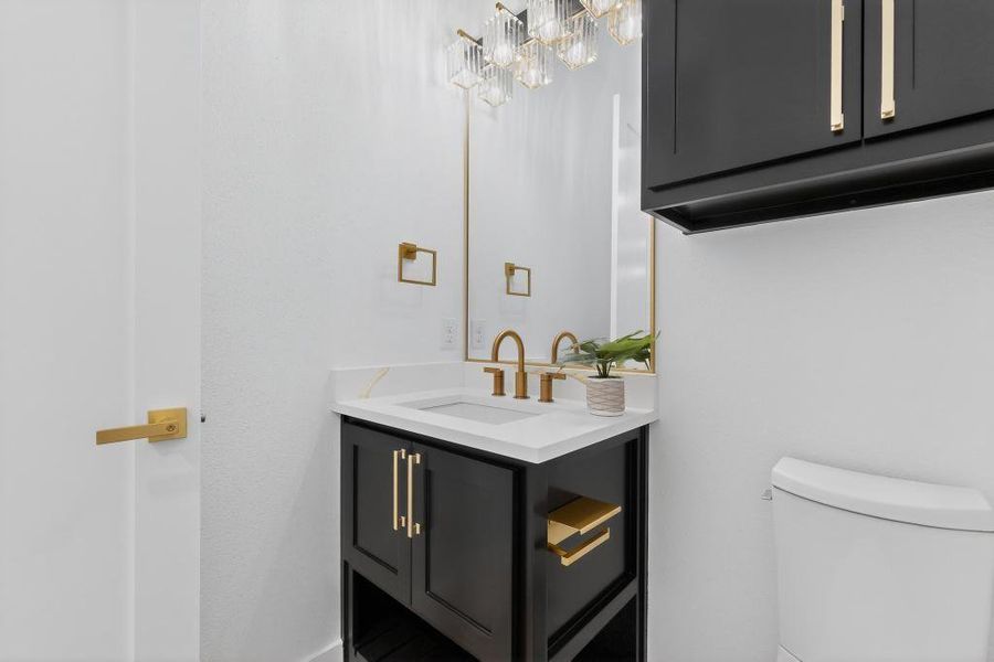 Half bathroom featuring vanity and toilet