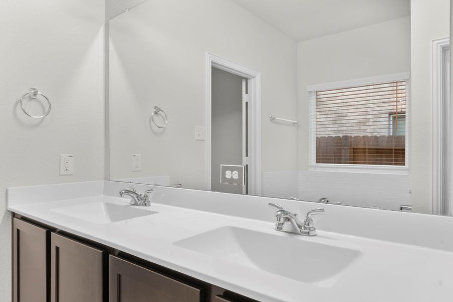 Another view of the dual vanity showcases abundant counter space and contemporary fixtures. Natural light pours through the window, creating a bright and inviting start to every morning. Another view of the dual vanity showcases abundant counter space and contemporary fixtures. Natural light pours through the window, creating a bright and inviting start to every morning.