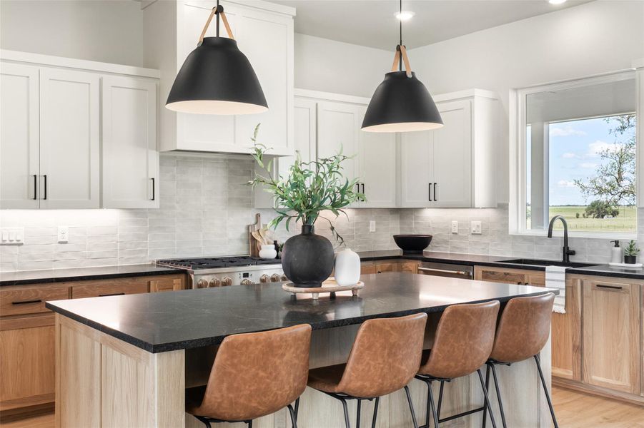 Kitchen featuring a sink, a center island, a breakfast bar area, backsplash, and hanging light fixtures Kitchen featuring a sink, a center island, a breakfast bar area, backsplash, and hanging light fixtures