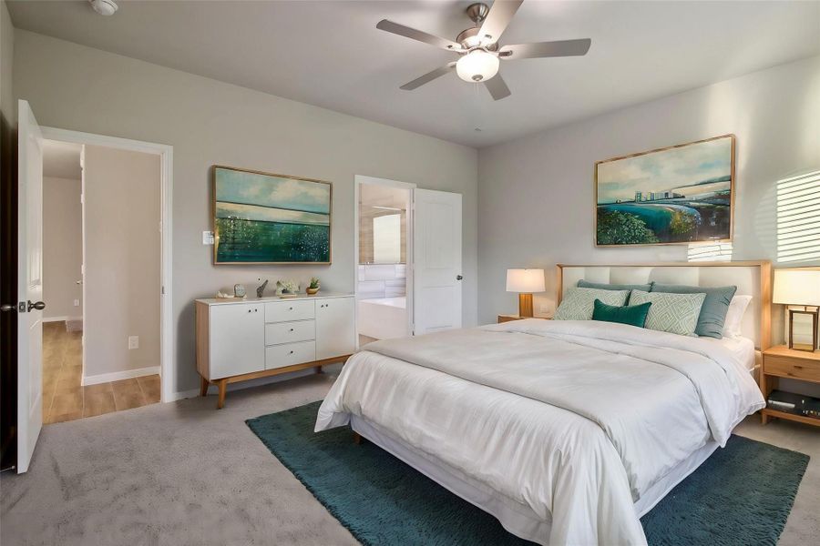 Step into this spacious primary bedroom with plush carpet and crisp, neutral-toned walls.