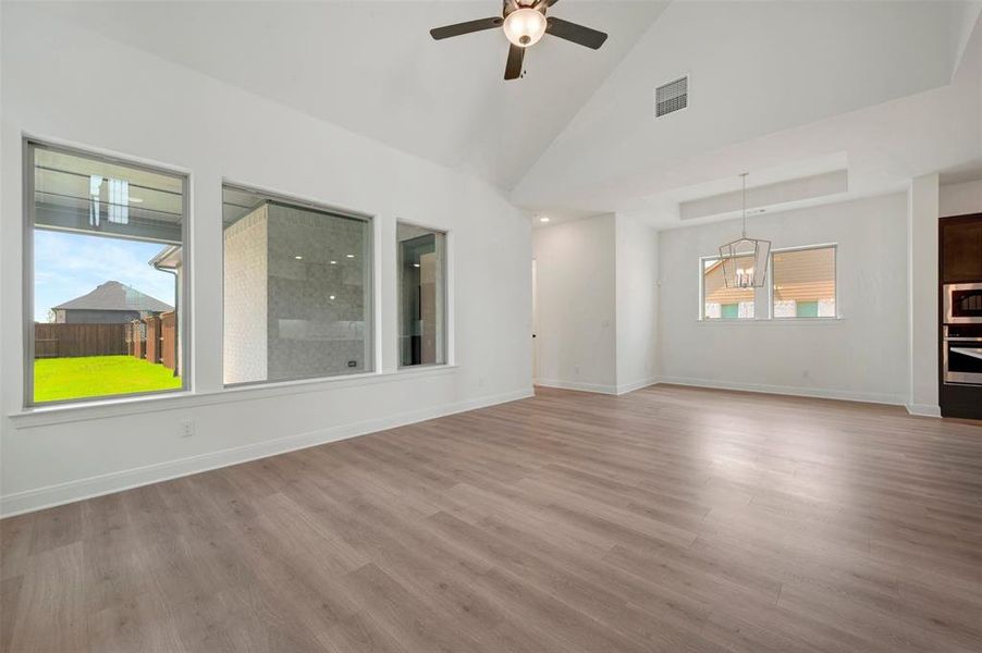 Spacious interior featuring wood-finish flooring, high vaulted ceilings, and a modern ceiling fan