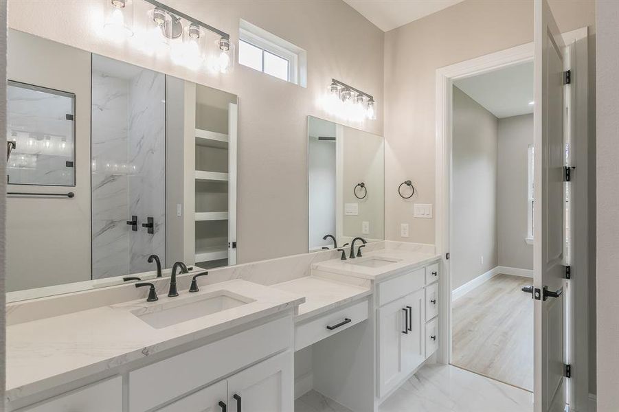 Full bath with double vanity, a marble finish shower, marble finish floors, and baseboards Full bath with double vanity, a marble finish shower, marble finish floors, and baseboards