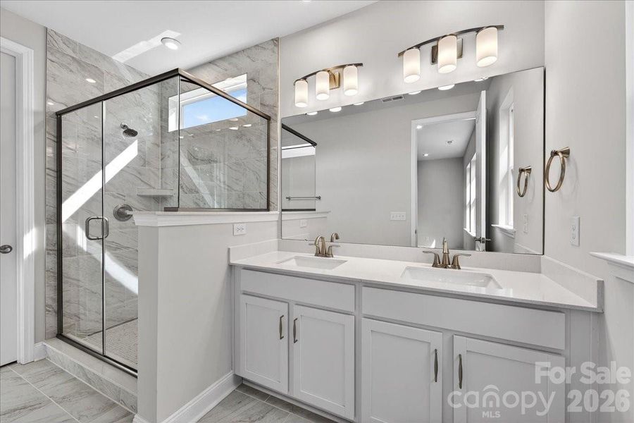 Dual vanity primary bathroom with walk-in shower