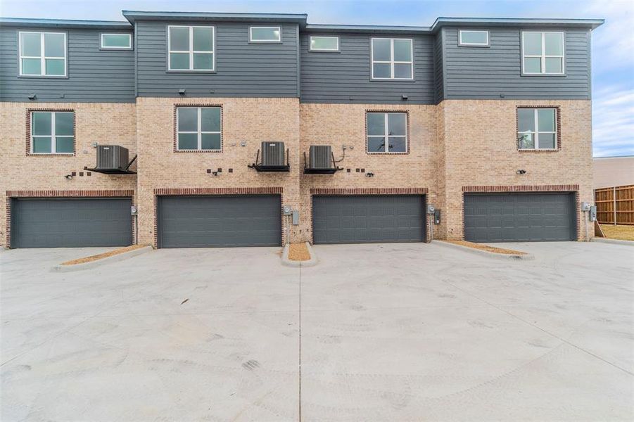 Townhome / multi-family property featuring a garage and central AC unit