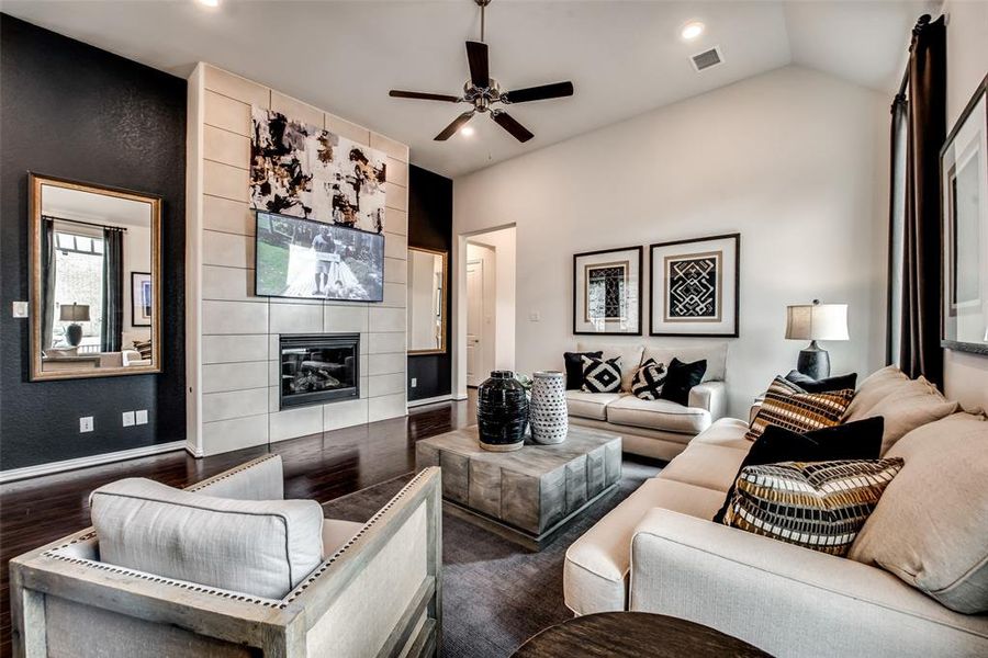 Living area with a fireplace, a ceiling fan, recessed lighting, and lofted ceiling