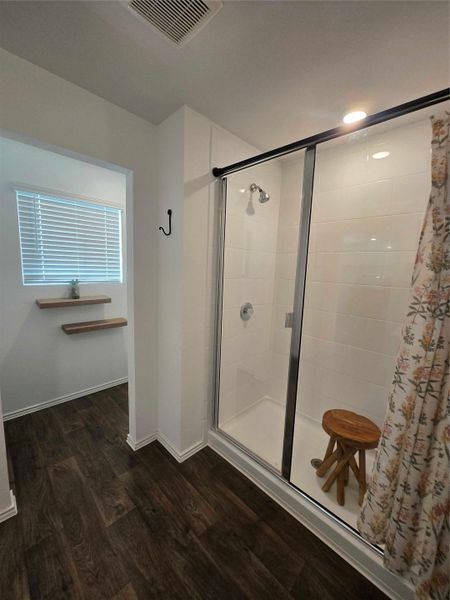 Shower enclosure featuring a sliding glass door and white subway tile surround