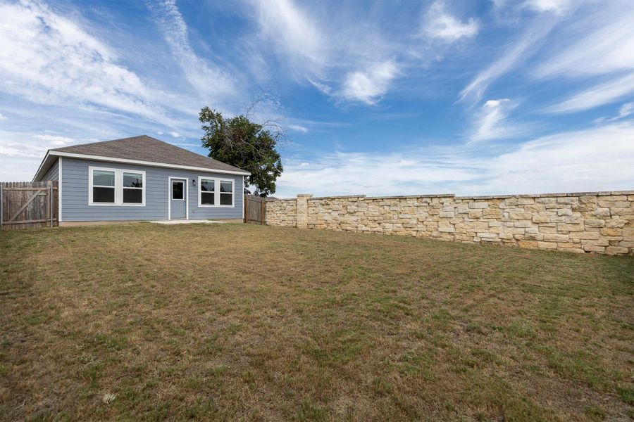 Fenced backyard with a patio area Fenced backyard with a patio area