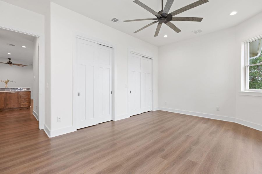 Unfurnished bedroom featuring light wood-type flooring, multiple closets, recessed lighting, and baseboards Unfurnished bedroom featuring light wood-type flooring, multiple closets, recessed lighting, and baseboards