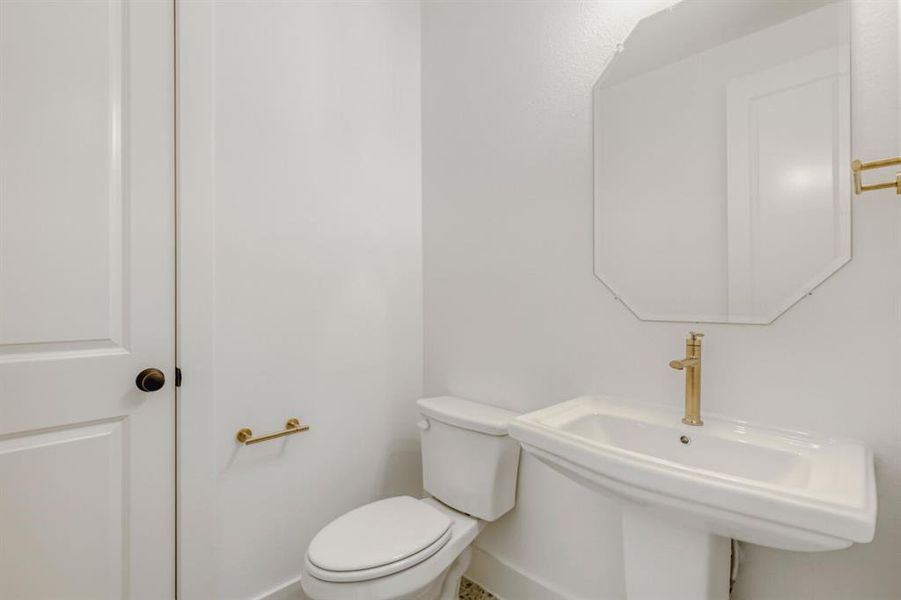 Half bathroom featuring toilet and a sink