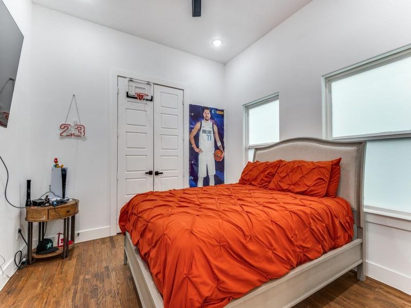 Bedroom with dark wood-style flooring, a closet, and ceiling fan