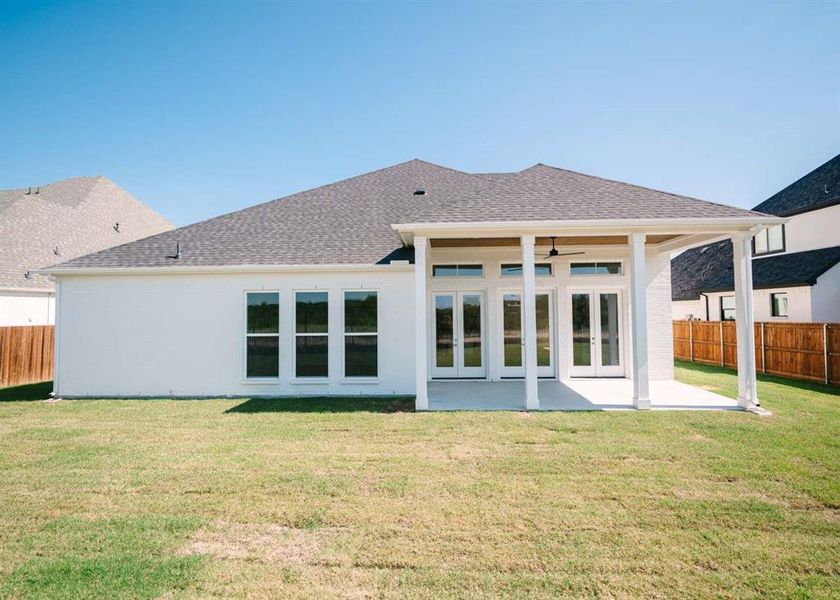 Rear view of house featuring a patio and a yard