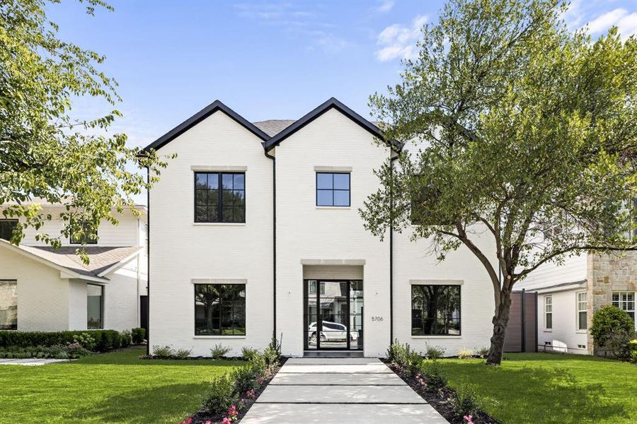 Modern farmhouse style home featuring a front yard and brick siding Modern farmhouse style home featuring a front yard and brick siding