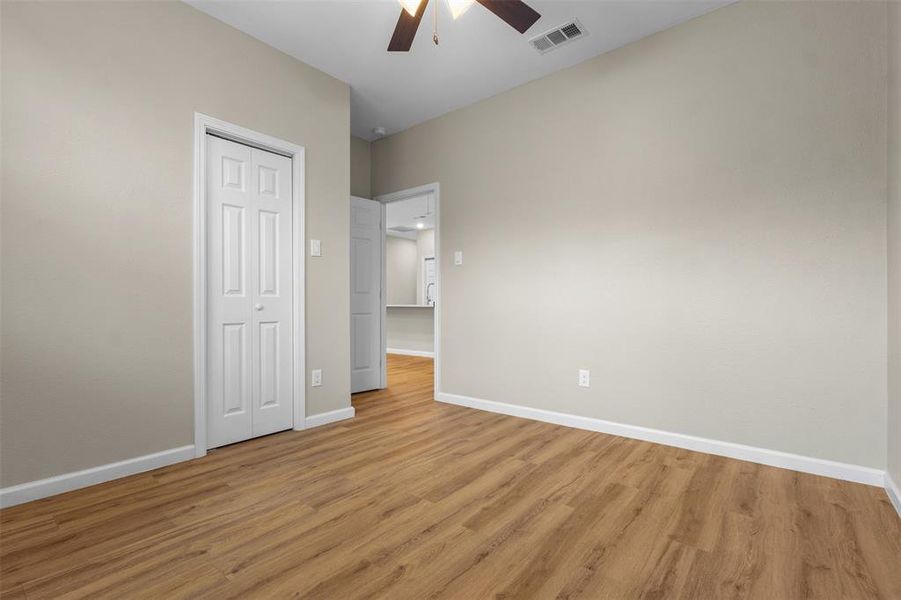 Unfurnished bedroom featuring light wood-style floors, ceiling fan, and a closet