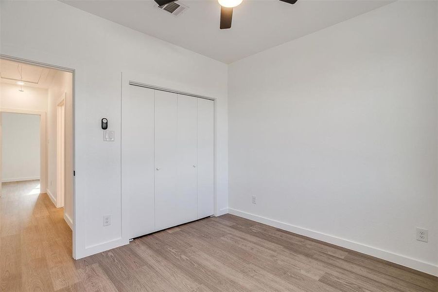 Bedroom 4 with ceiling fan, a closet, and light hardwood / wood-style floors Bedroom 4 with ceiling fan, a closet, and light hardwood / wood-style floors