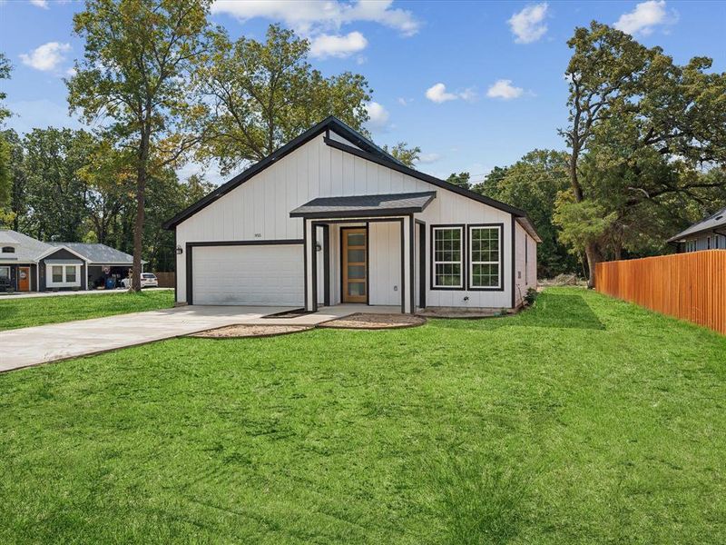 View of front facade with a garage and a front lawn