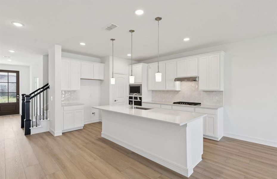 Large island overlooking gathering room and dining areas