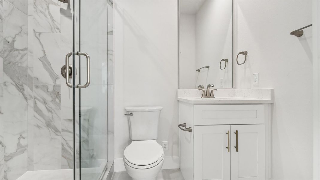 Bathroom featuring a marble finish shower and vanity Bathroom featuring a marble finish shower and vanity