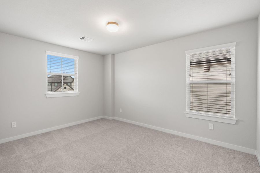 Secondary bedrooms showcase 5-panel doors adorned with modern hardware, large windows enhanced by privacy blinds, and spacious closets featuring sleek and contemporary finishes. Sample photo of completed home with similar floor plan. As-built interior colors and selections may vary. Secondary bedrooms showcase 5-panel doors adorned with modern hardware, large windows enhanced by privacy blinds, and spacious closets featuring sleek and contemporary finishes. Sample photo of completed home with similar floor plan. As-built interior colors and selections may vary.