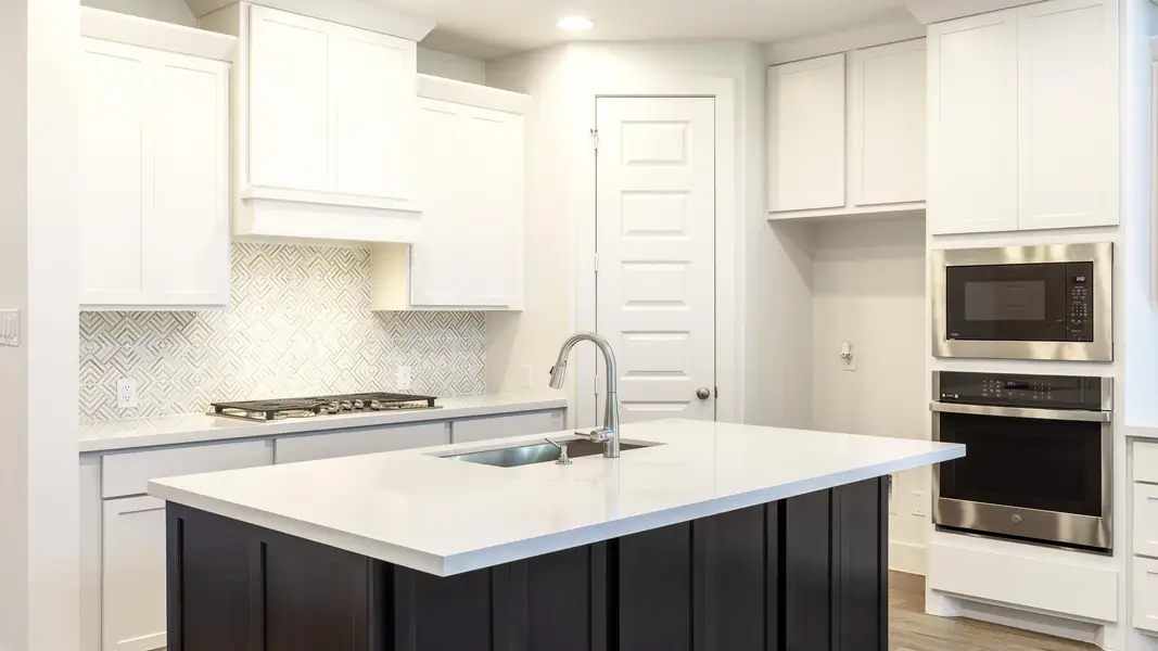 Kitchen with a sink, white cabinetry, decorative backsplash, light countertops, and appliances with stainless steel finishes Kitchen with a sink, white cabinetry, decorative backsplash, light countertops, and appliances with stainless steel finishes