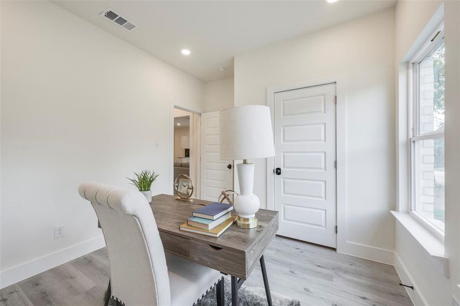 Office area with light wood finished floors and recessed lighting