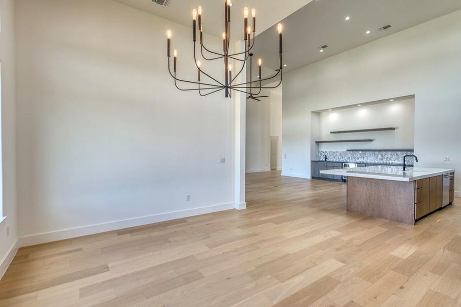 Clean lines and smooth hardwood flooring define this open, airy kitchen and dining area.